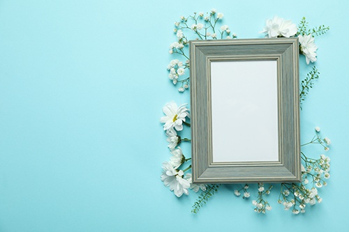 دانلود فایل  قاب عکس خالی با گل در پس زمینه آبی